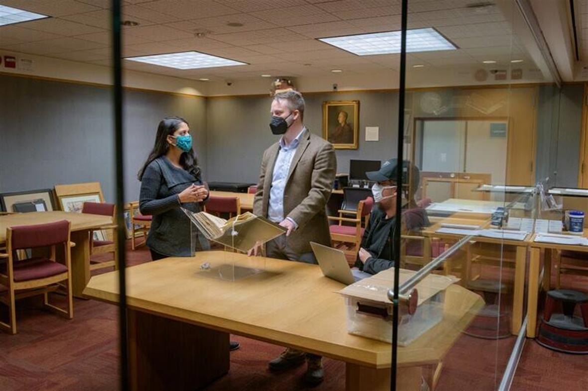 Students Anisha Gupta amd Tyler Welsh with Prof. Dael Norwood in Special Collections.